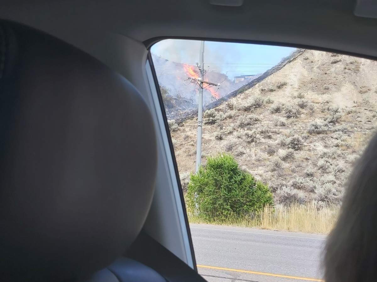 Flames and smoke rise from the fire alongside Highway 97 near Penticton.