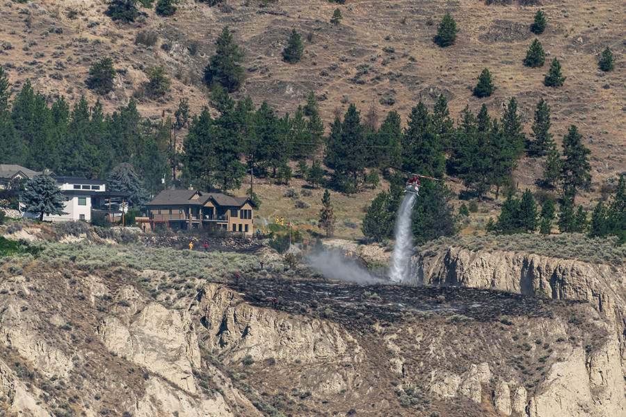 A helicopter bucketing water on the fire.