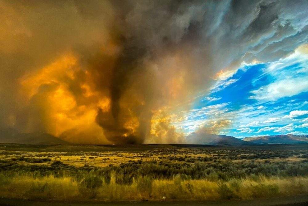This photo provided by Katelynn and Jordan Hewlett, a funnel appears in a thick plume of smoke from the Loyalton Fire in Lassen County, Calif. on Saturday, Aug. 15, 2020.