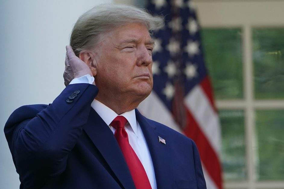 U.S. President Donald Trump pats down his hair as he speaks during the Coronavirus Task Force daily briefing on COVID-19 in the Rose Garden of the White House in Washington, DC on March 30, 2020.