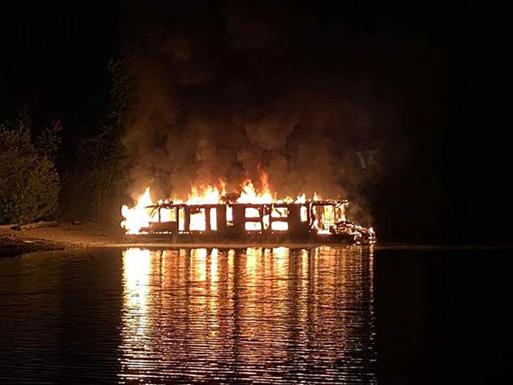 Flames tear through a houseboat on Mara Lake early Tuesday. A witness said the 21 people aboard the houseboat escaped safely.