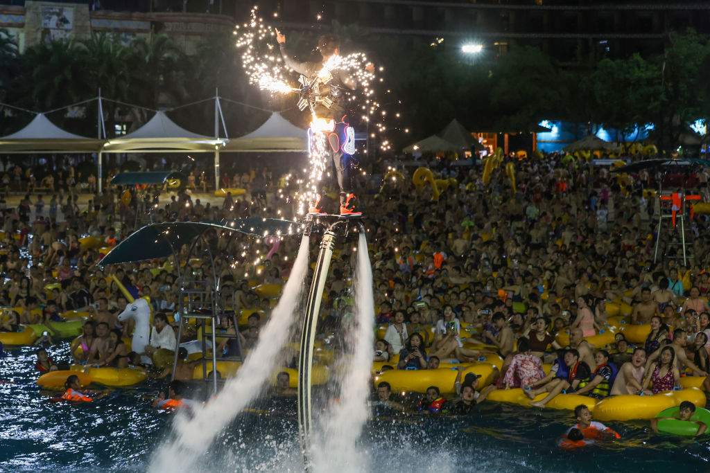 This photo taken on Aug. 15, 2020 shows people watching a performance as they cool off in a swimming pool in Wuhan in China’s central Hubei province.