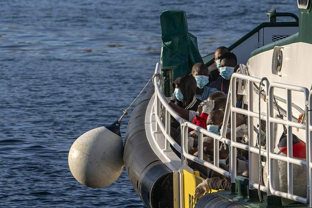 Migrants wearing face masks sit on the deck of a police rescue boat as they arrive at the Arguineguin port in Gran Canaria island, Spain, after being rescued in the Atlantic Ocean on Thursday, Aug. 20, 2020. More than 250 people are known to have died or gone missing in the Atlantic route so far this year.