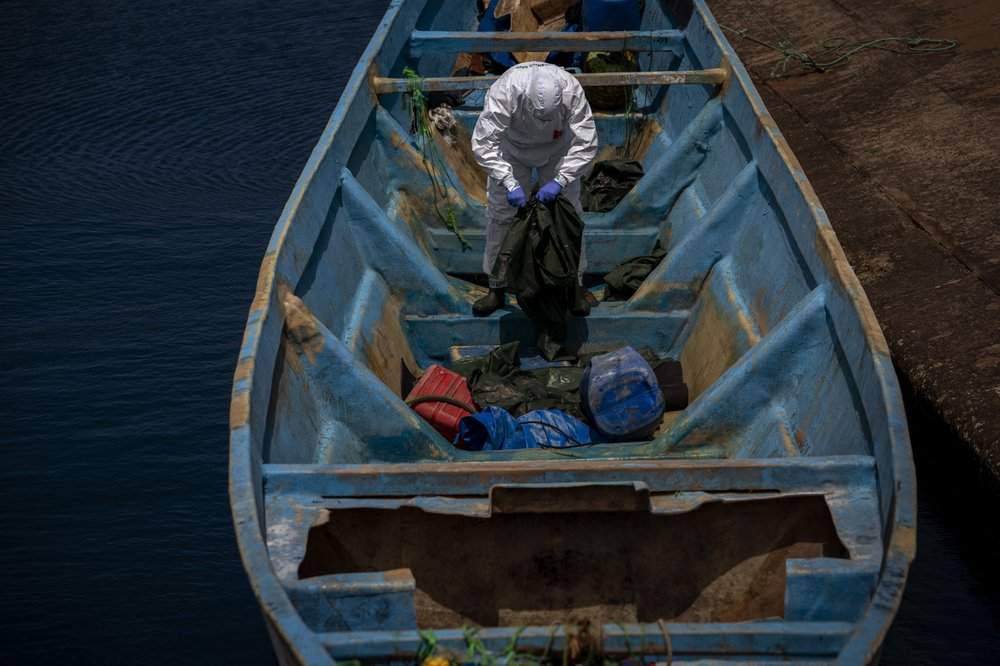 A police officer inspects a boat where 15 Malians were found dead adrift in the Atlantic on Thursday, Aug. 20, 2020 in Gran Canaria island, Spain. The 15 lifeless men were spotted inside a boat on Aug. 19 by a Spanish plane 80 nautical miles (148 kilometers, 92 miles) from the island of Gran Canaria. Police collected what was left behind as evidence: a wallet, a dozen cell phones, windbreakers and galoshes.