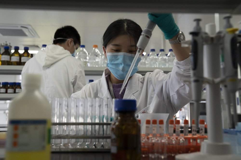 An employee of SinoVac works in a lab at a factory producing its SARS CoV-2 Vaccine for COVID-19 named CoronaVac in Beijing on Thursday, Sept. 24, 2020. SinoVac's CEO says they have injected 90 percent of its employees and family members, or about 3,000 people, and provided tens of thousands of rounds of CoronaVac to the municipal government of Beijing. It's a highly unusual move that raises ethical and safety questions, as companies and governments worldwide race to develop a vaccine that will stop the spread of the new coronavirus. 