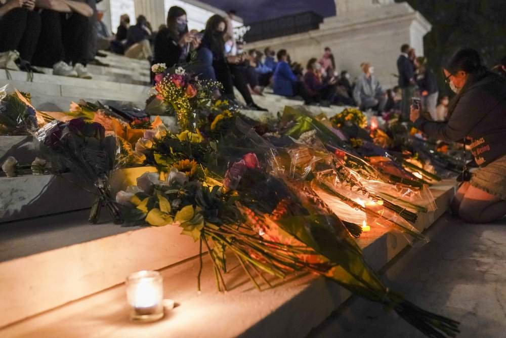 People gather at the Supreme Court Friday, Sept. 18, 2020, in Washington, after the Supreme Court announced that Supreme Court Justice Ruth Bader Ginsburg has died of metastatic pancreatic cancer at age 87.