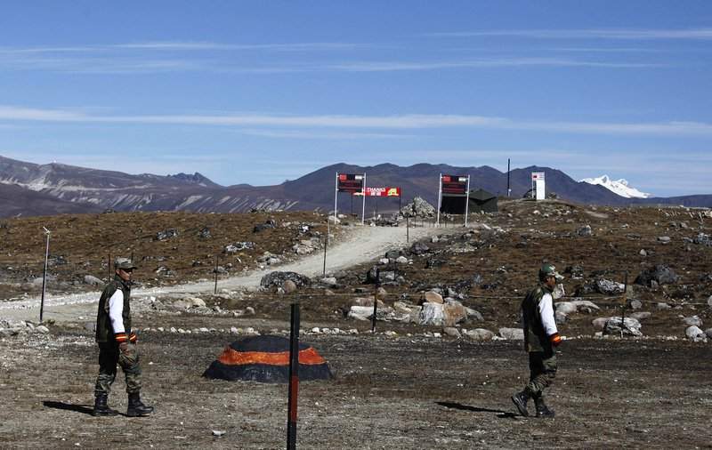 FILE - In this Sunday, Oct. 21, 2012, file photo, Indian army soldiers walk along the line of control at the India- China border in Bumla in the northeastern Indian state of Arunachal Pradesh. The Indian army said Saturday, Sept. 12, 2020, that China has released five Indian nationals who went missing earlier this month from the state of Arunachal Pradesh amid simmering tensions between the two countries along a disputed mountain frontier. The five men were hunters and will be quarantined for 14 days as a precaution against the coronavirus before being handed over to their families, the army said in a statement.
