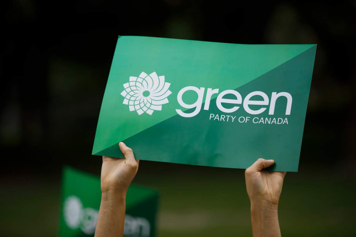 A supporter holds a sign for the Green Party of Canada in a Tuesday, Sept. 3, 2019, file photo.