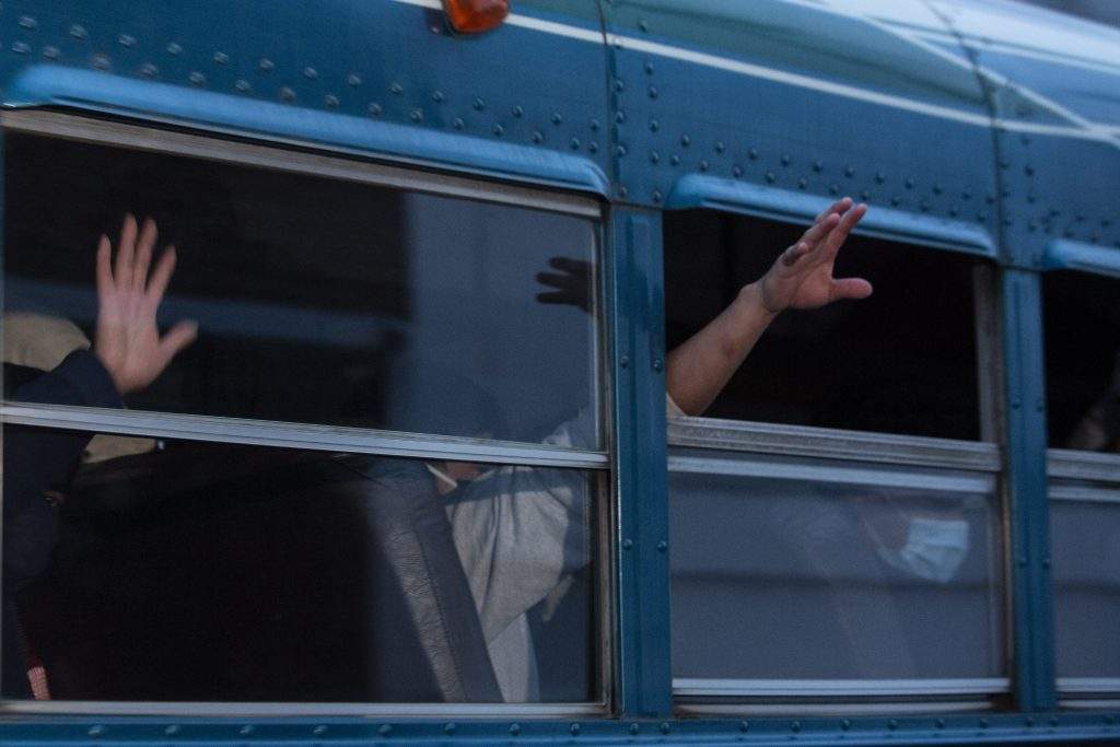FILE - In this May 4, 2020, file photo, Guatemalans deported from the U.S., wave from a bus after arriving at La Aurora airport in Guatemala City. U.S. border agencies quickly expelled about 600 child migrants in April after federal agencies began prohibiting asylum claims at the southern border, citing the coronavirus pandemic. 