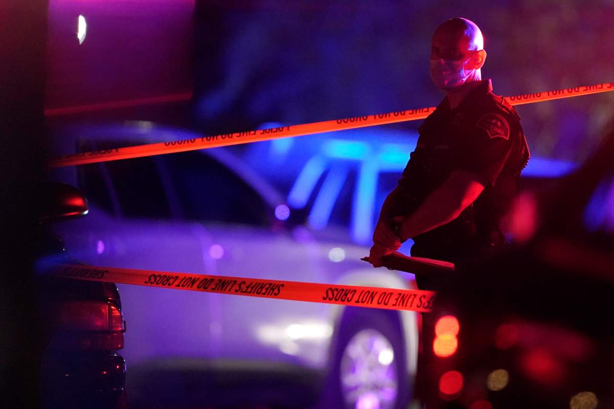 A Thurston County Sheriff's Deputy wears a mask as he stands near crime scene tape, Thursday, Sept. 3, 2020, in Lacey, Wash. at the scene where Michael Reinoehl was killed Thursday night as investigators moved in to arrest him.