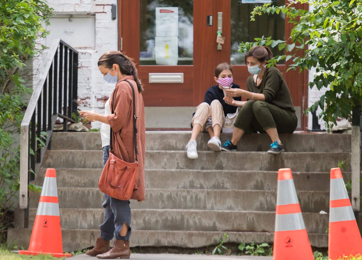 People wear face masks as they wait to enter a COVID-19 testing clinic in Montreal, Monday, September 7, 2020, as the COVID-19 pandemic continues in Canada and around the world. 
