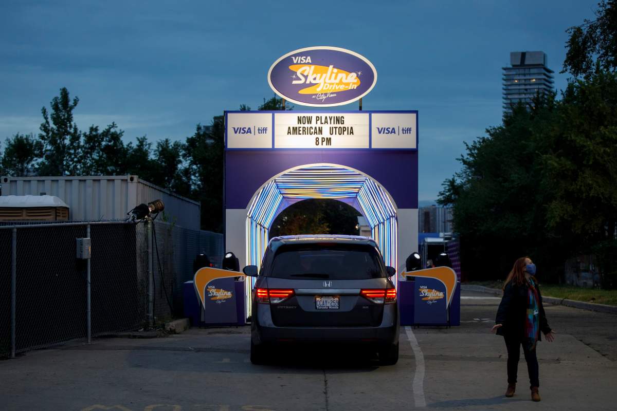 An attendant directs a car into Toronto International Film Festival’s Visa Skyline Drive-In at CityView ahead of the TIFF drive-in premier of David Byrne’s American Utopia, in Toronto, Thursday, Sept. 10, 2020.