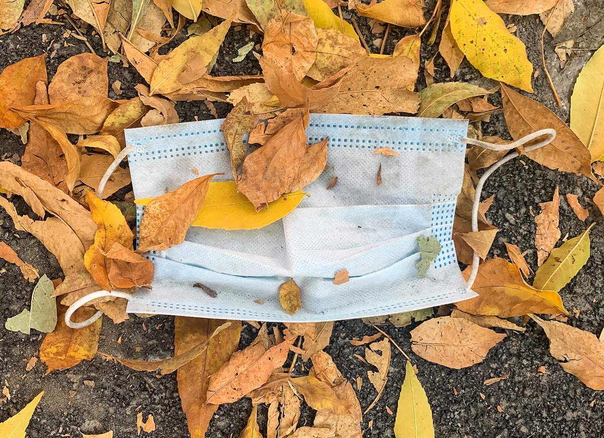 A discarded face mask is shown amongst fallen leaves in Montreal, Monday, September 22, 2020. 