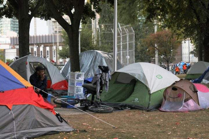 Tents set up by the homeless are seen in Moss Park in downtown Toronto on Wednesday, Sept. 23, 2020, as activists march in a nearby street. 