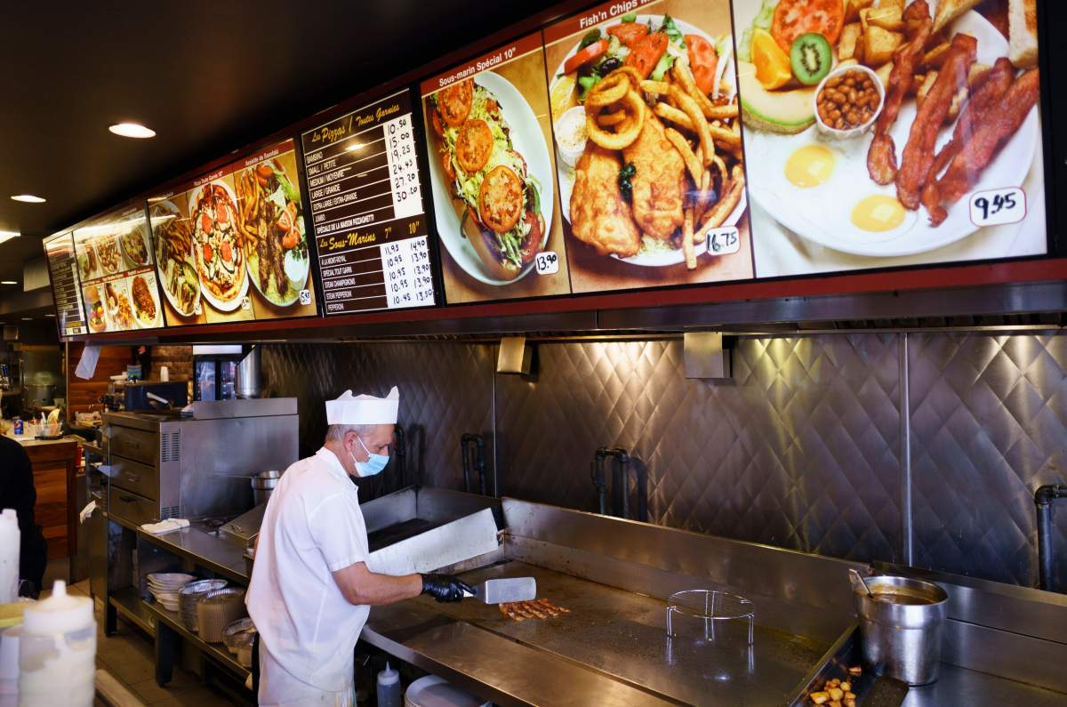 Charlie works the grill at a local diner in Montreal, on Wednesday, September 30, 2020. Bars, restaurant and dining rooms in red zones in Quebec will close at midnight for 28 days as of midnight Wednesday. 