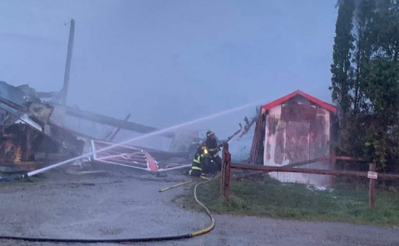 Firefighters pour water on a building at the Woodstock Fairgrounds Tuesday evening.