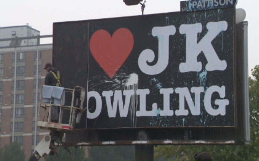 Crews remove a billboard declaring love for author JK Rowling in Vancouver, after it was defaced on Saturday, Sept. 12, 2020. 