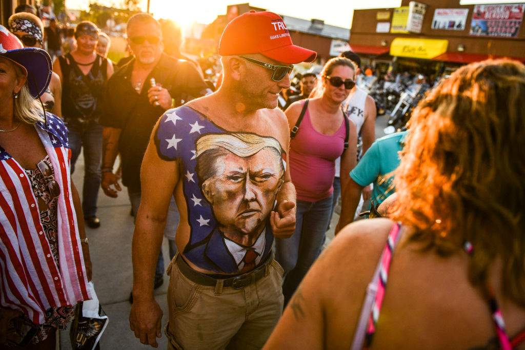 A man shows off his chest painted with a portrait of President Donald Trump during the 80th Annual Sturgis Motorcycle Rally on Aug. 7, 2020, in Sturgis, S.D.