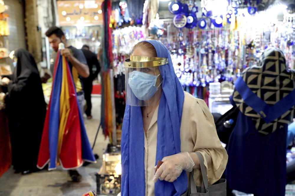 A woman wearing a protective face mask and gloves to help prevent the spread of the coronavirus walks through the Tajrish traditional bazaar in northern Tehran, Iran, Thursday, Oct. 15, 2020. Eight months after the pandemic first stormed Iran, pummeling its already weakened economy and sickening officials at the highest levels of its government, authorities appear just as helpless to prevent its spread. 
