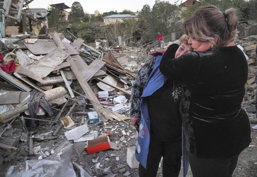 A neighbour comforts home owner, Lida Sarksyan, left, near her house destroyed by shelling from Azerbaijan’s artillery during a military conflict in Stepanakert, the separatist region of Nagorno-Karabakh, Oct. 17, 2020.