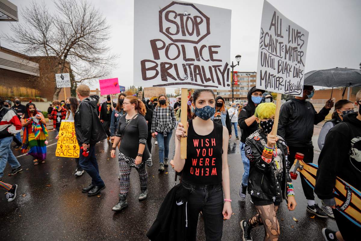 Demonstrators march down a street during an anti-racism event in Red Deer, Alta., Sunday, Oct. 4, 2020.