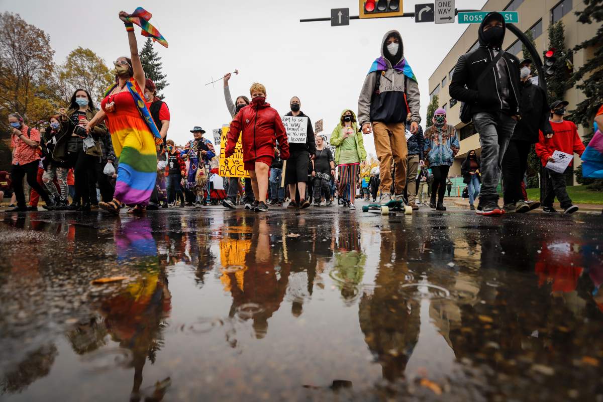 Demonstrators march down a street during an anti-racism event in Red Deer, Alta., Sunday, Oct. 4, 2020.