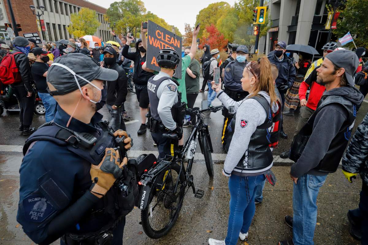 Police officers stand between counter-protesters and demonstrators as they march during an anti-racism event in Red Deer, Alta., Sunday, Oct. 4, 2020.