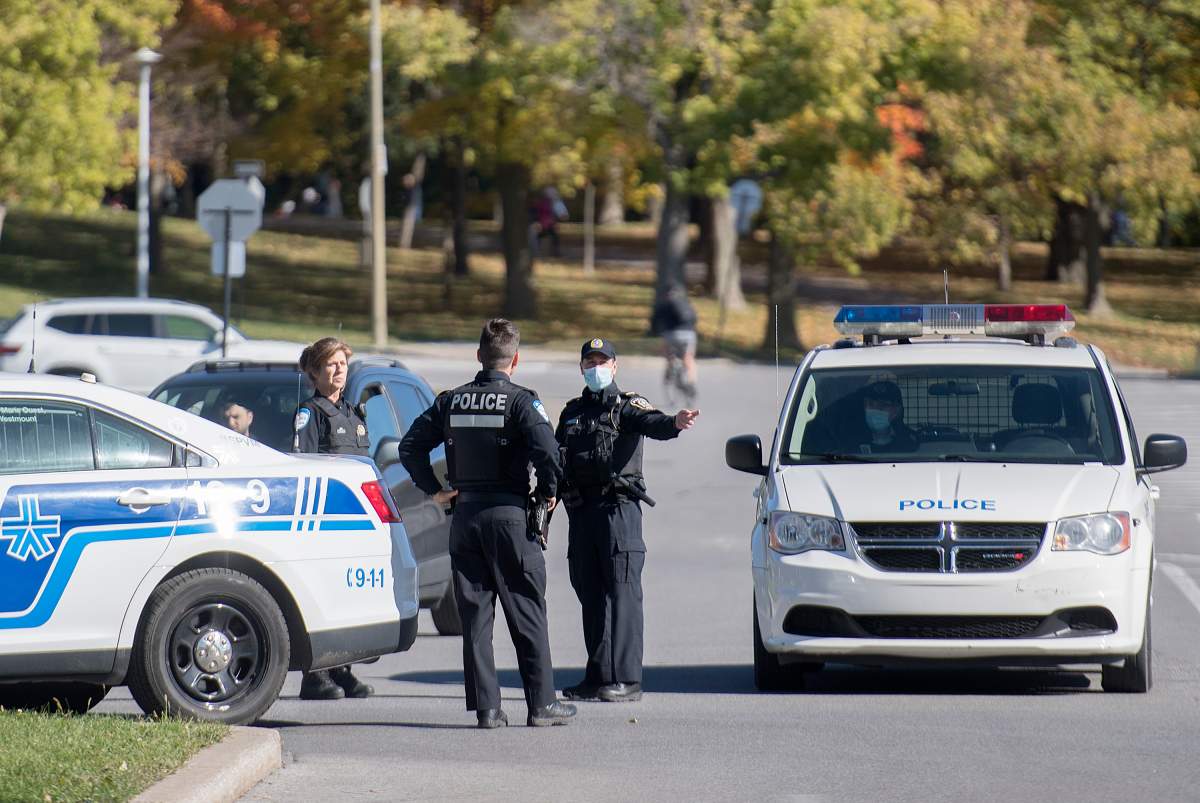 Police officers talk as the block the entrance to a parking lot in Mount Royal Park in Montreal, Monday, October 12, 2020, as the COVID-19 pandemic continues in Canada and around the world. 