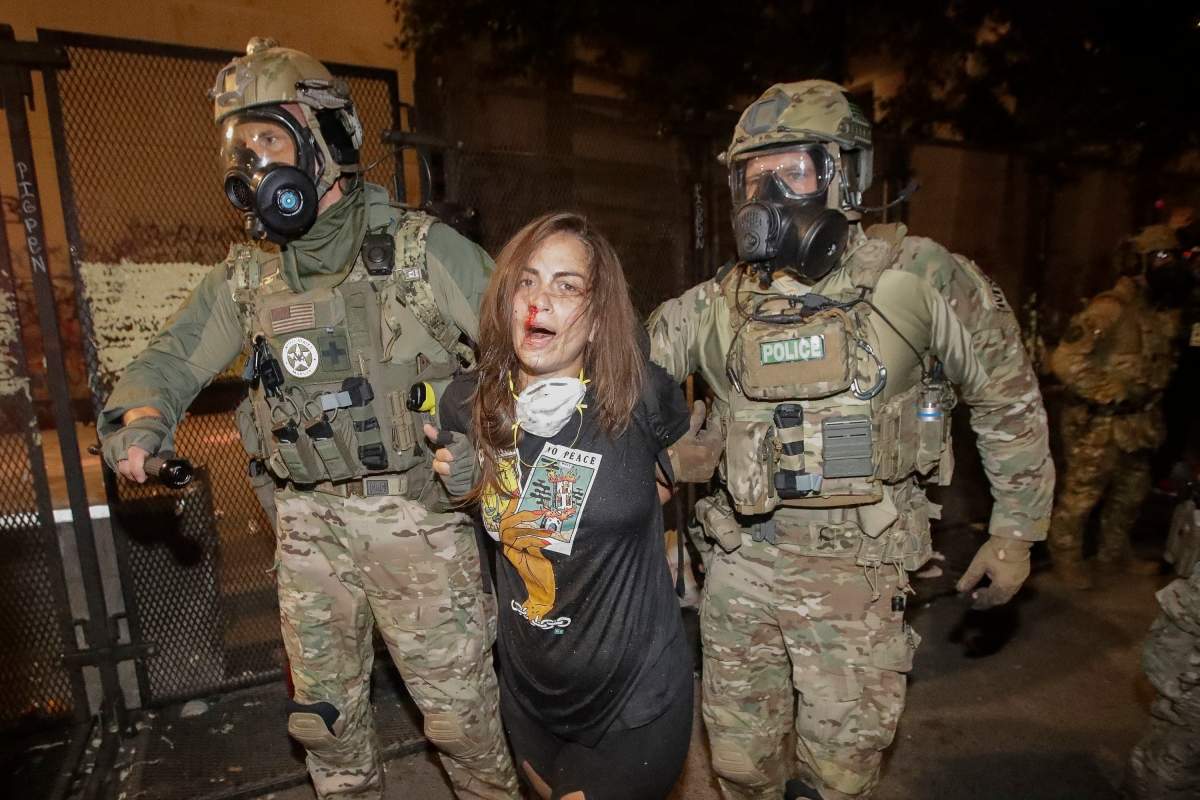 FILE - In this July 27, 2020, file photo, a bloodied demonstrator is arrested by federal police during a Black Lives Matter protest at the Mark O. Hatfield United States Courthouse in Portland, Ore.