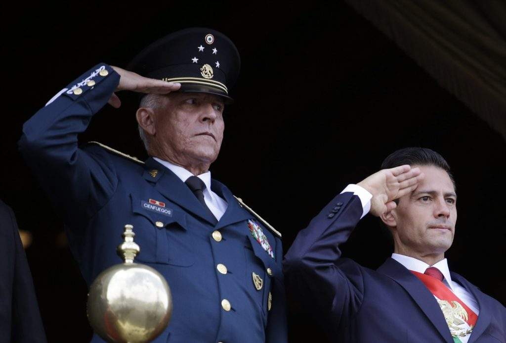 FILE - In this Sept. 16, 2016 file photo, Defense Secretary Gen. Salvador Cienfuegos, left, and Mexico's President Enrique Pena Nieto, salute during the annual Independence Day military parade in Mexico City's main square. Mexico's top diplomat says the country's former defense secretary, Gen. Salvador Cienfuegos, has been arrested in Los Angeles. Foreign Relations Secretary Marcelo Ebrard wrote Thursday, Oct. 15, 2020 in his Twitter account that U.S. Ambassador Christopher Landau had informed him of Cienfuegos' arrest. 