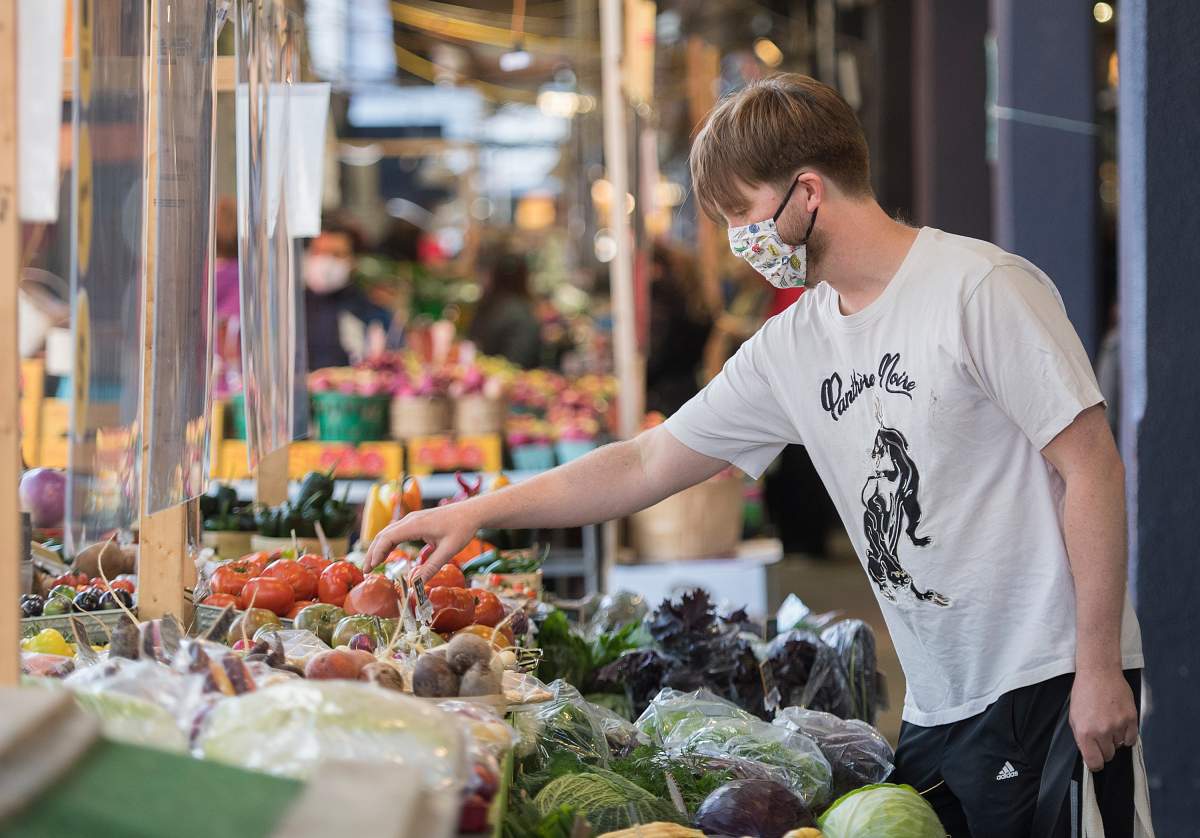 A man wears a face mask as he shops at a market in Montreal, Sunday, Oct. 18, 2020, as the COVID-19 pandemic continues in Canada and around the world. 