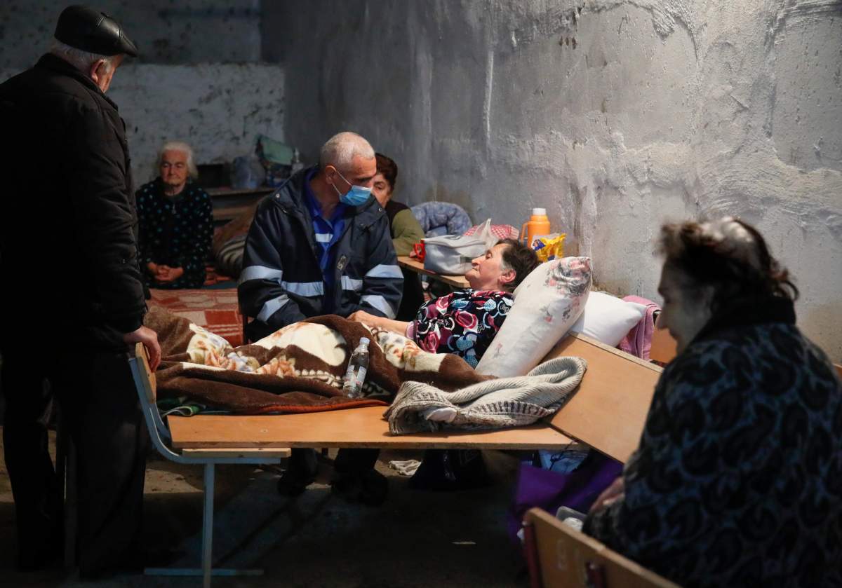 A medical worker talks to a sick woman in a bomb shelter in Stepanakert, the separatist region of Nagorno-Karabakh, Oct. 22, 2020.