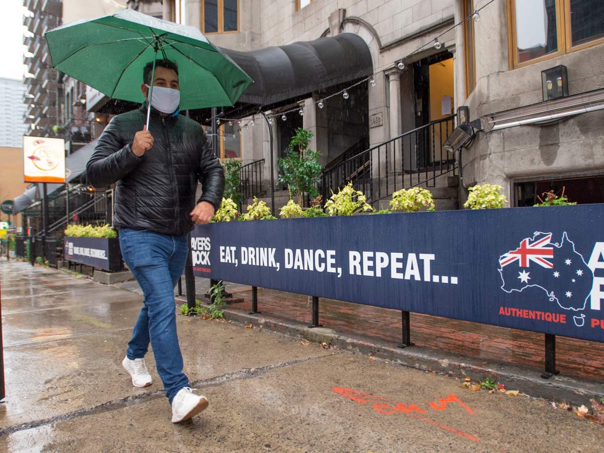 A man walks past a closed pub on Crescent Street Monday, Oct. 26, 2020 in Montreal.