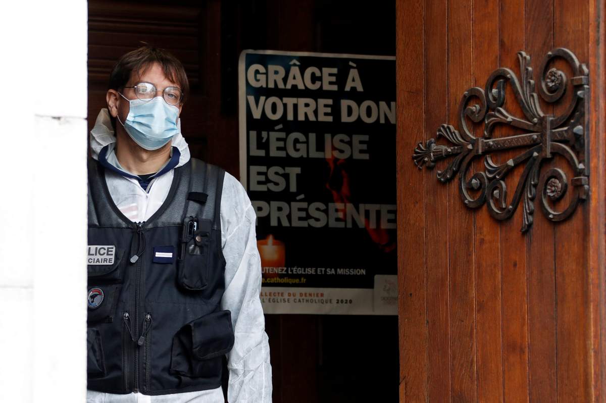 A police officer stands at the entrance of the Notre Dame church in Nice, southern France, Thursday, Oct. 29, 2020.