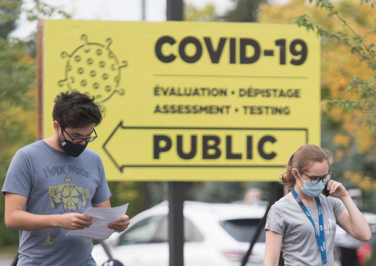 People wear face masks outside a COVID-19 testing clinic in Montreal, Sunday, Sept. 27, 2020, as the COVID-19 pandemic continues in Canada and around the world. 