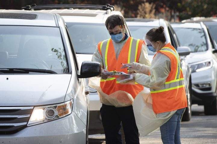 Staff tests people in their vehicle at the drive-thru COVID-19 assessment centre.