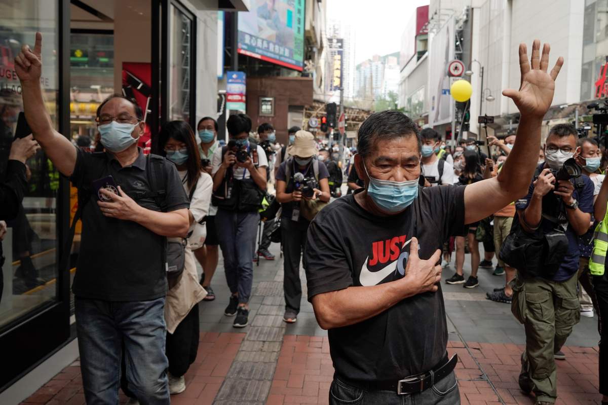Protesters raise five fingers, signifying their "Five demands and not one less" as they march in Causeway Bay, Hong Kong, during China's National Day, Thursday, Oct. 1, 2020.