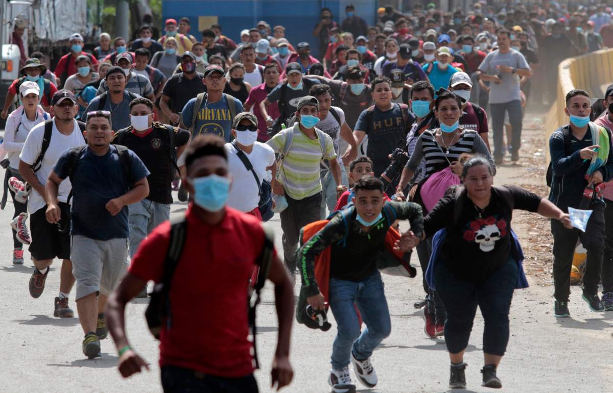 Migrants attempt to cross the border from Corinto, Honduras, into Corinto, Guatemala, Thursday, Oct. 1, 2020.
