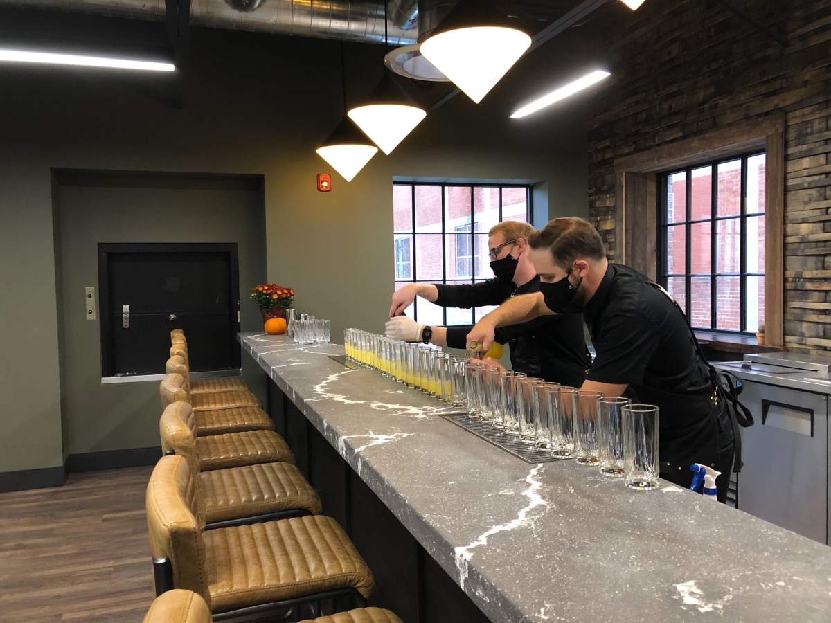 Bartenders prepare drinks during a preview of Paradigm Spirits Co.’s new craft distillery at 100 Kellogg Lane.