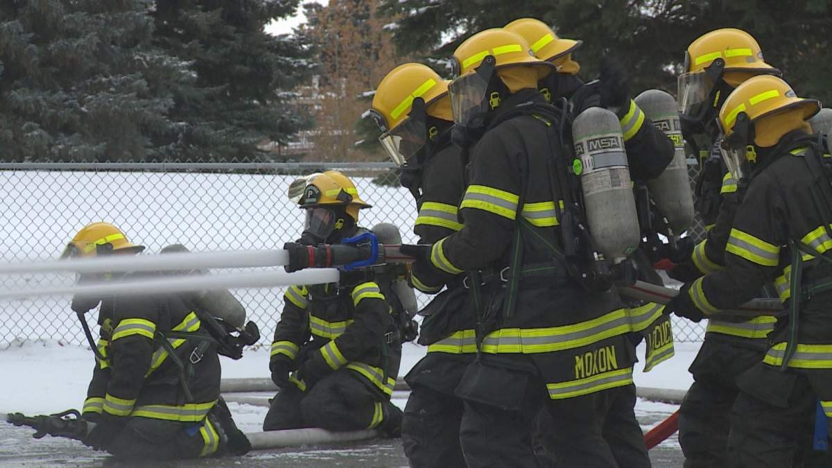 Nine of the twelve Lethbridge firefighter recruits demonstrating a fire exercise at the training facility on 5 Ave. N on Monday morning.