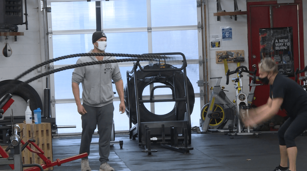 Brickhouse Gym owner Paul Taylor coaching a client during a workout session.