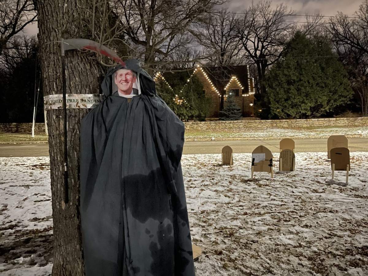 A photo of Manitoba Premier Brian Pallister is placed inside a Grim Reaper costume as part of a protest outside his Winnipeg home on Saturday, Oct. 31, 2020.