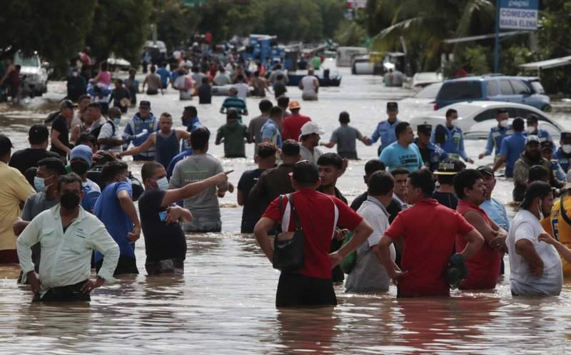 Residents wade through a flooded road in the aftermath of Hurricane Eta in Planeta, Honduras, Thursday, Nov. 5, 2020. The storm that hit Nicaragua as a Category 4 hurricane on Tuesday had become more of a vast tropical rainstorm, but it was advancing so slowly and dumping so much rain that much of Central America remained on high alert.
