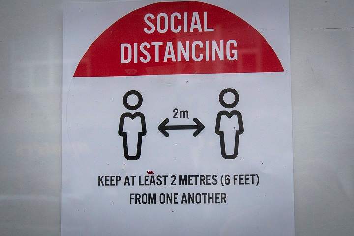 A sign telling people to social distance in Kingston, Ont., on Thursday, Oct. 22, 2020.
