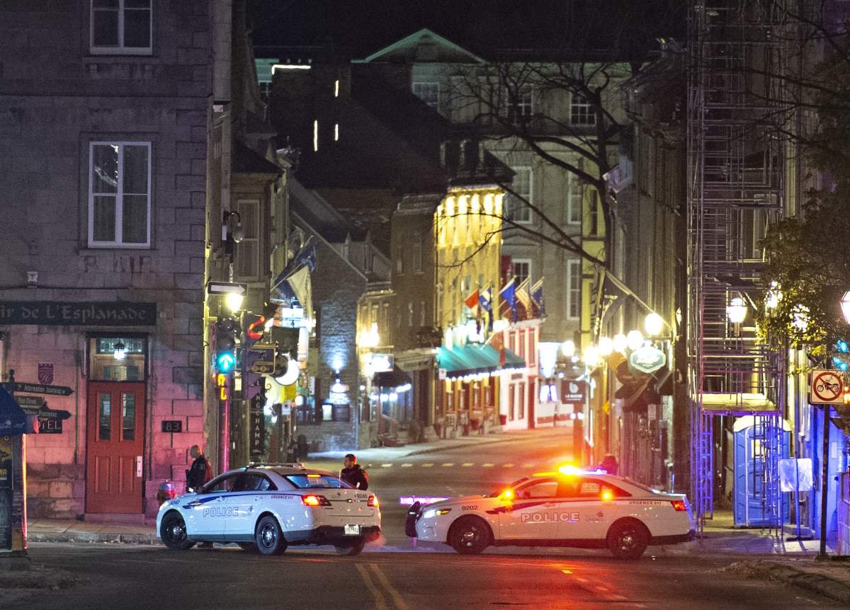 Police cars block the Saint-Louis Street near the Chateau Frontenac, early Sunday, November 1, 2020 in Quebec City. A man wearing medieval clothed was arrested. Two people are dead and five people were injured after they were stabbed. 