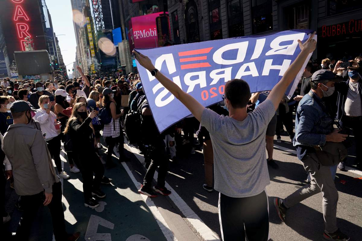 People celebrate in Times Square after former vice president and Democratic presidential candidate Joe Biden was announced as the winner over Pres. Donald Trump to become the 46th president of the United States, Saturday, Nov. 7, 2020, in New York.