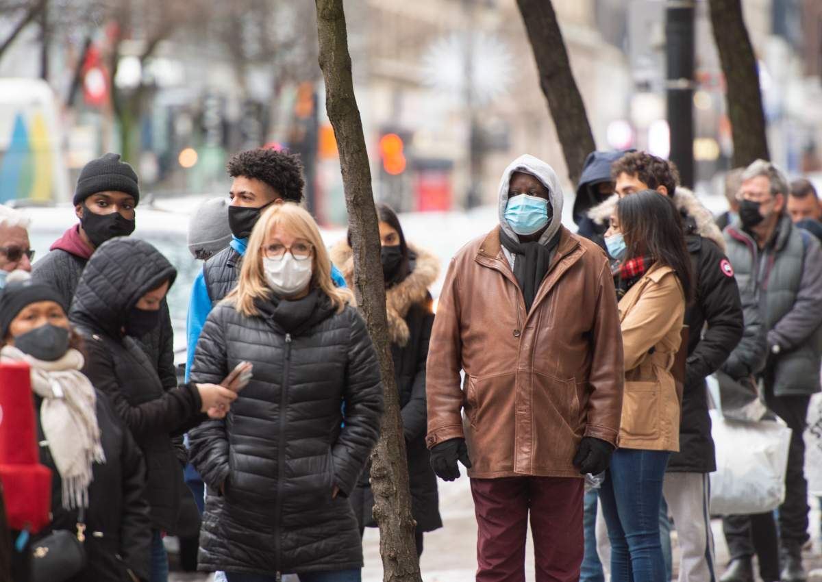 People line up at a store Monday on, Nov. 23, 2020, as the COVID-19 pandemic continues to impact businesses in Montreal.