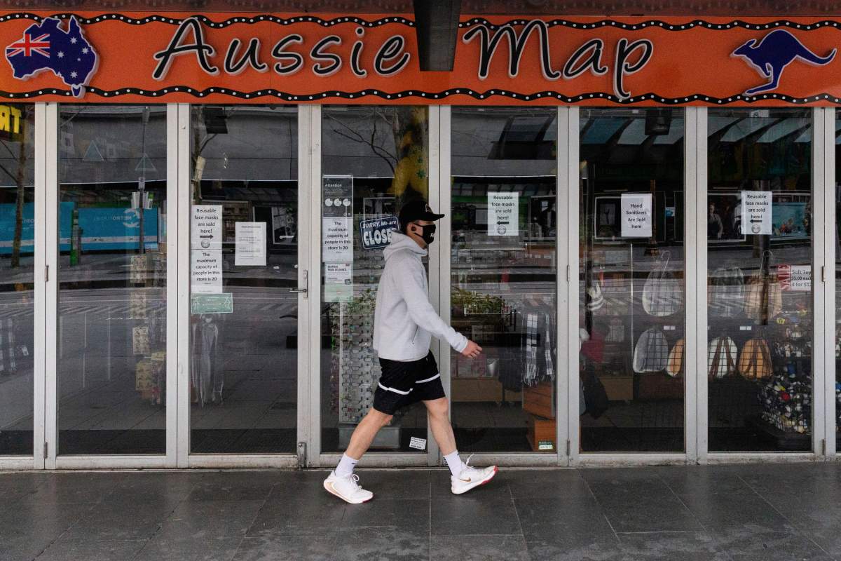 A man walks past a shop closed down store selling Australian paraphernalia items aimed at International tourists during lockdown in Melbourne, Australia, Wednesday, Aug. 5, 2020.