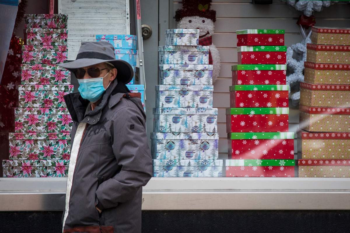 A person wears a mask as they walk past Christmas decorations in a store in Kingston, Ontario on Thursday, November 19, 2020, as the COVID-19 pandemic continues across Canada and around the world. 