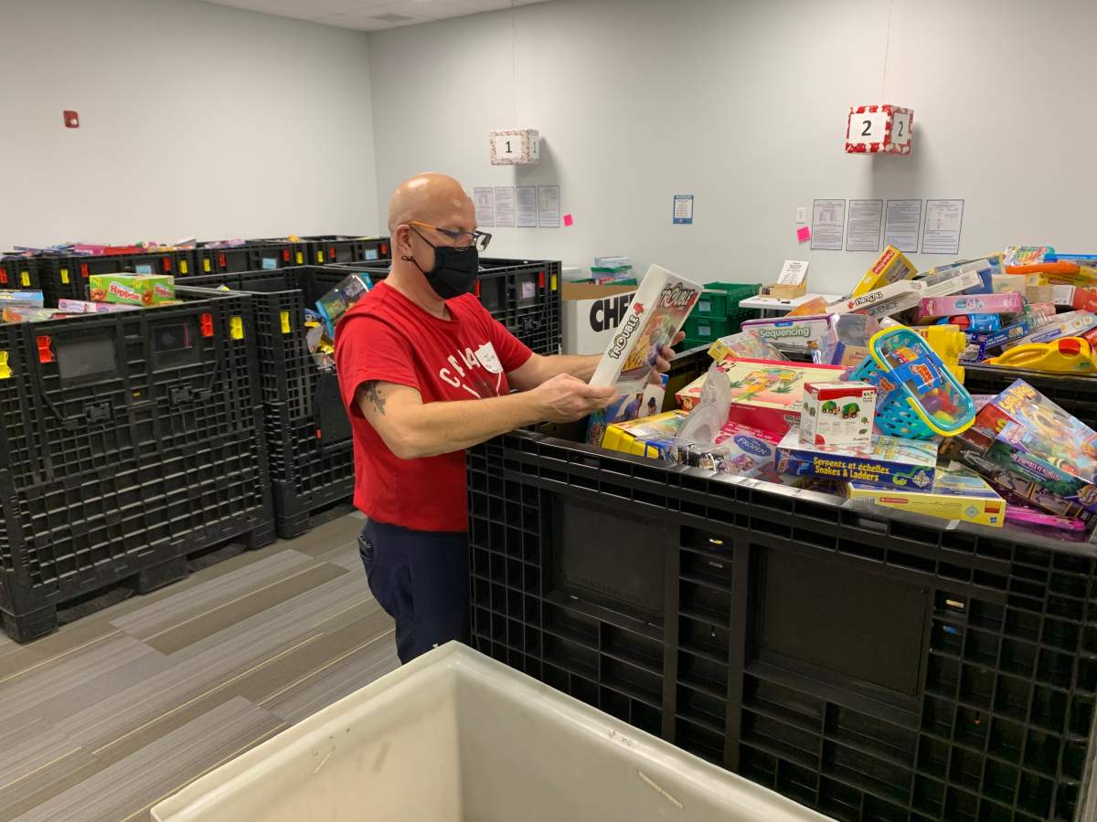 A volunteer prepares gift packages at 630 CHED Santas Anonymous.